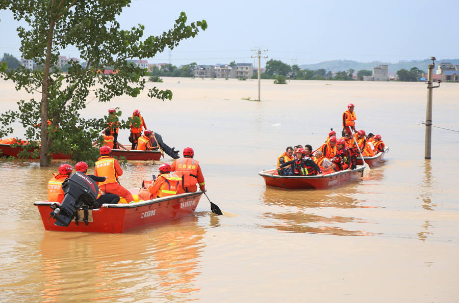 7月11日下午A江西鄱陽縣A消防隊員衝鋒舟接載被困村民離開被洪水圍困的村莊]中新社^