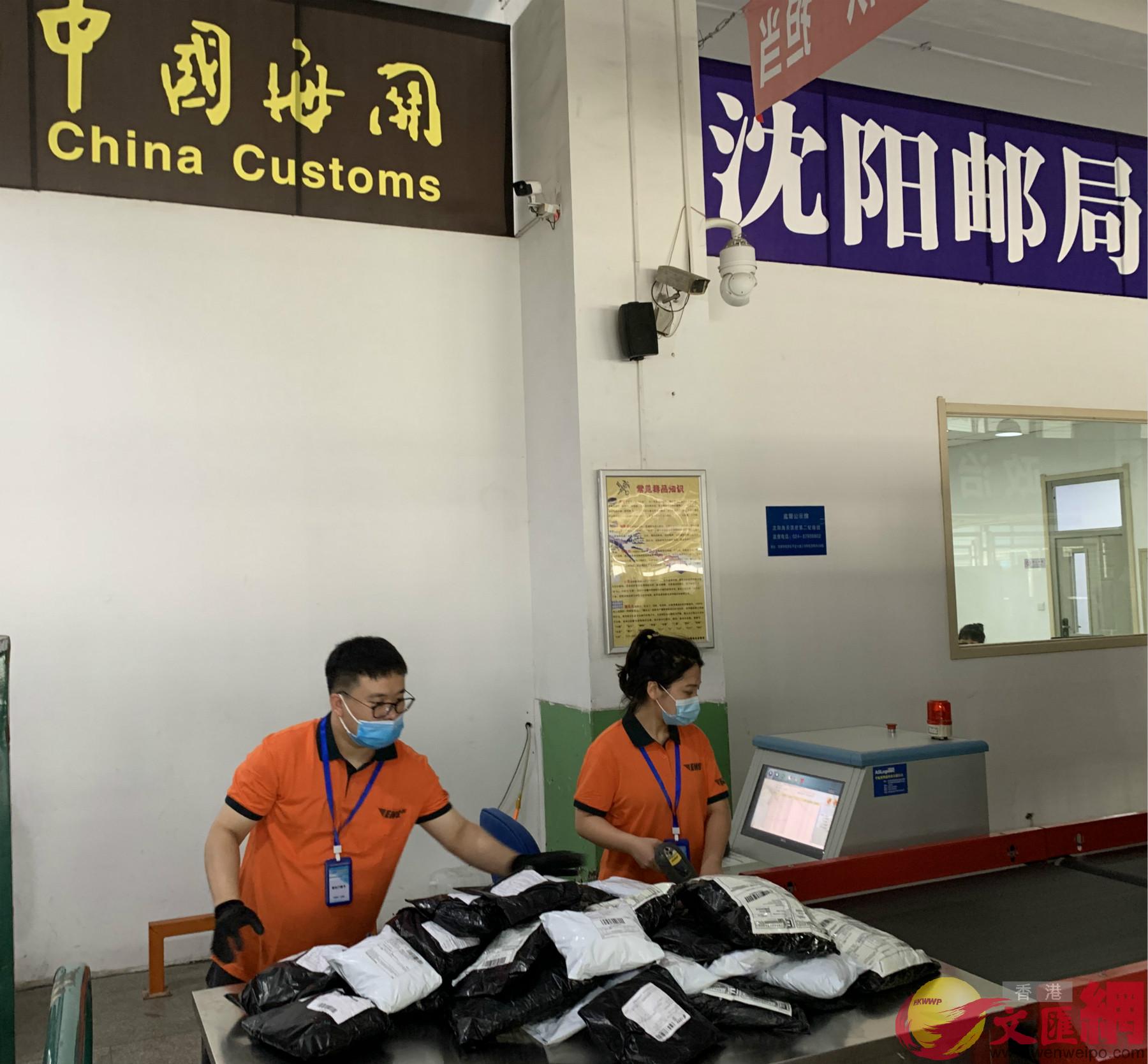 遼寧郵政速遞快件監管中心工作人員在分揀等待出口的貨物]記者 于珈琳攝^