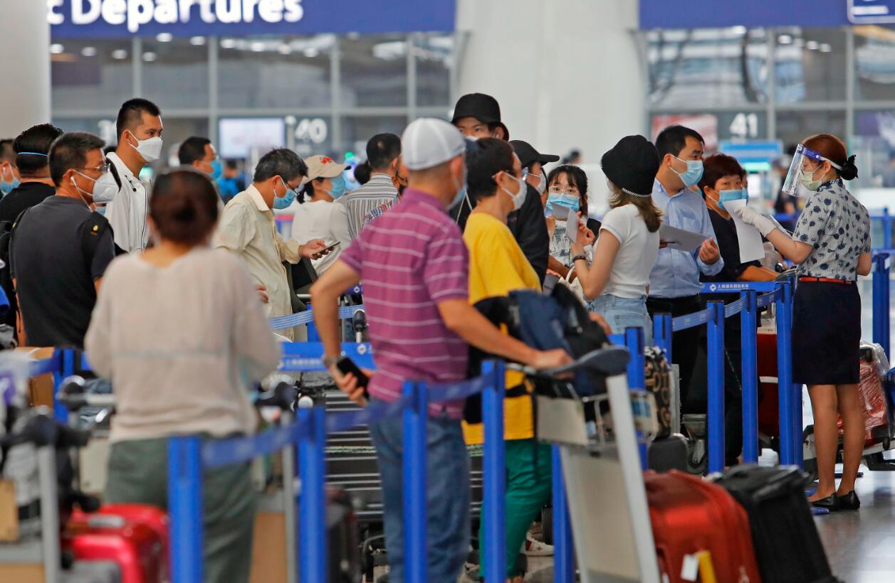在上海浦東國際機場T2航站樓內A航空公司工作人員指導旅客填寫出入境健康聲明卡C]中新社^