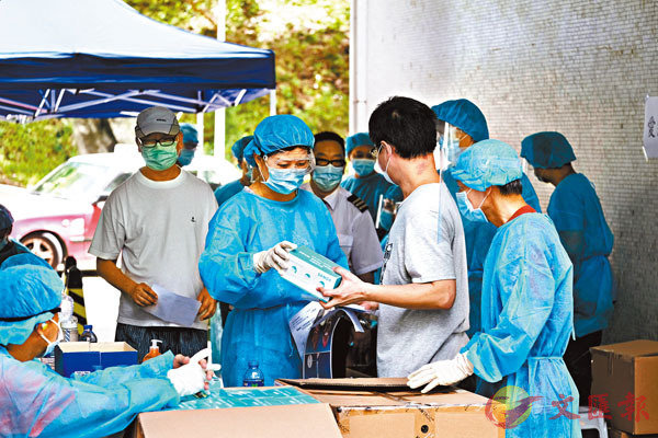 香港9月1日起啟動普及社區檢測計劃C圖為早前身穿防護衣的工作人員在黃大仙慈愛邨派發新冠病毒檢測套裝和表格C]資料圖片^