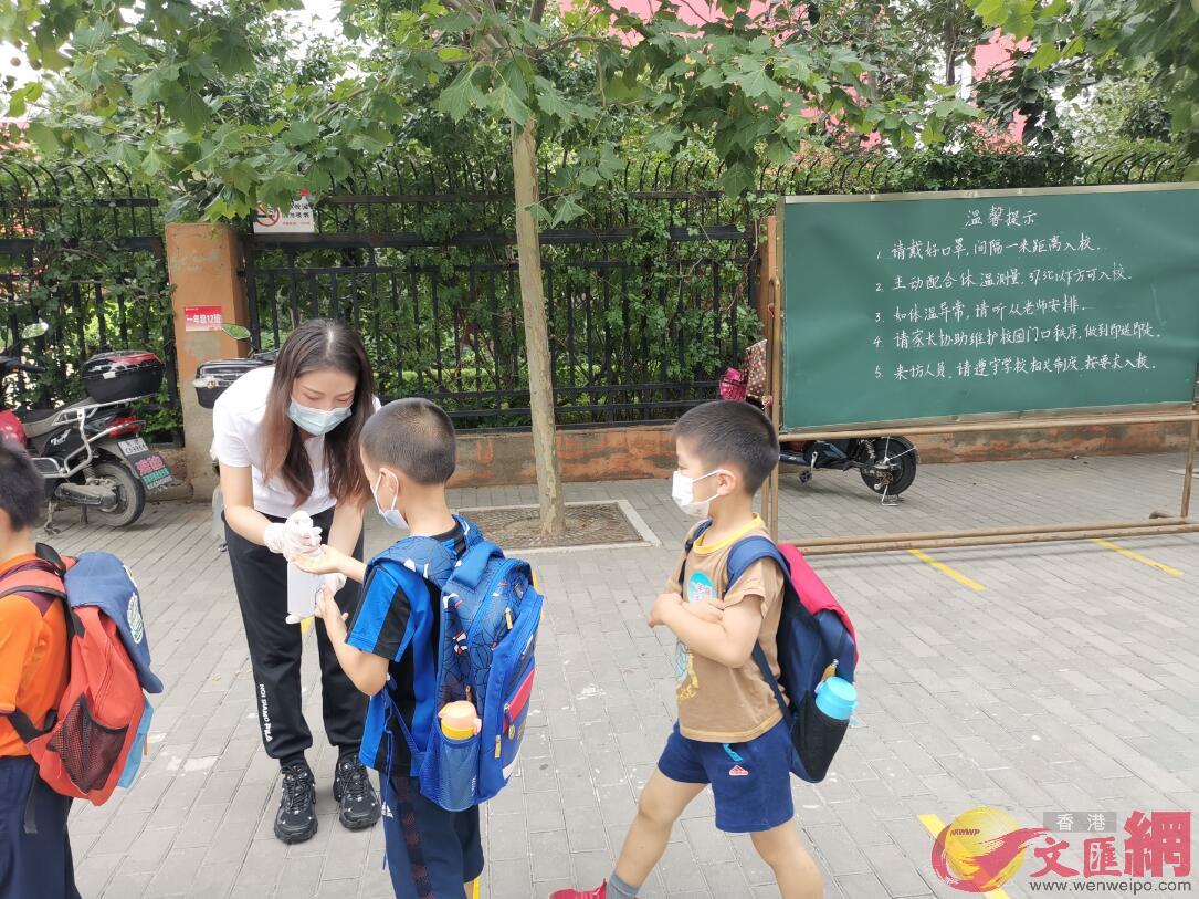 北京市海澱區中關村二小百旺校區的老師為學生提供手部消毒液C 記者 江鑫嫻 攝